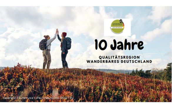 Zwei Frauen klatschen sich mit erhobenen Händen ab - 10 Jahre Qualitätsregion Wanderbares Deutschland