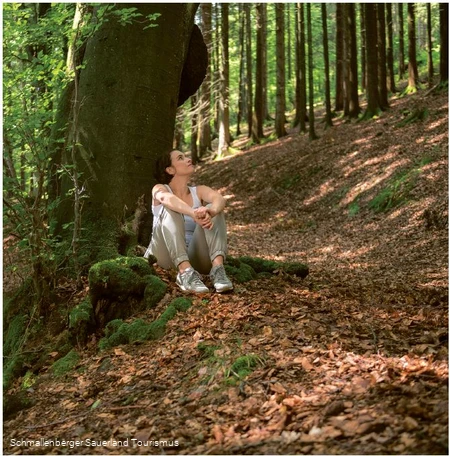 Eine Frau genießt die Stille im Wald